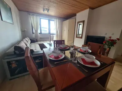 a dining room table with plates and bowls on it at Saphir apartment , Rhodopi Pearl Pamporovo in Pamporovo