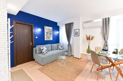 a living room with a blue accent wall at Lyana's One Bedroom apartment in Bansko
