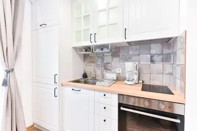 a kitchen with white cabinets and a counter top at Lyana's One Bedroom apartment in Bansko