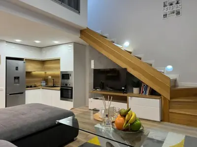a living room with a table with fruit on it at Modern Vitosha Maisonette with Garage in Sofia
