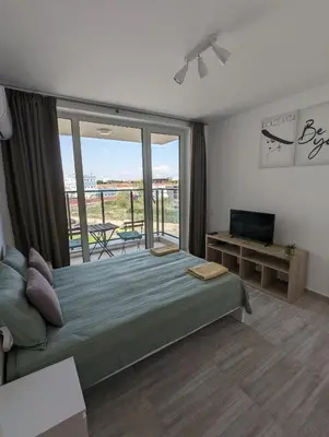 a bedroom with a large bed and a balcony at Reina Apartment- next to Sofia zoo and close to Mall Paradise in Sofia