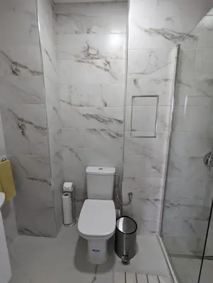 a white bathroom with a toilet and a shower at Reina Apartment- next to Sofia zoo and close to Mall Paradise in Sofia