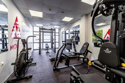 a gym with treadmills and bikes in a room at Парк Хотел Модър in Devin