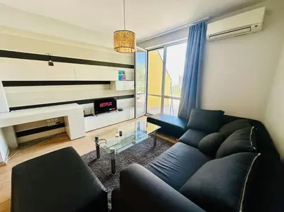 a living room with a couch and a tv at Student Town 1BDR APT in Sofia