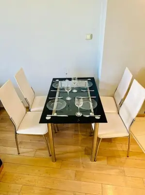 a black table with white chairs and wine glasses at Student Town 1BDR APT in Sofia