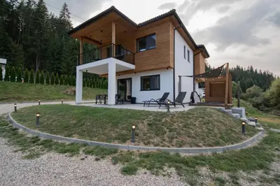 a house on a hill with a round yard at Hyggemate - Nordic Villa with Sauna & Jacuzzi Retreat in Sarnitsa