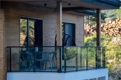 a screened in porch with a table and chairs on it at Hyggemate - Nordic Villa with Sauna & Jacuzzi Retreat in Sarnitsa