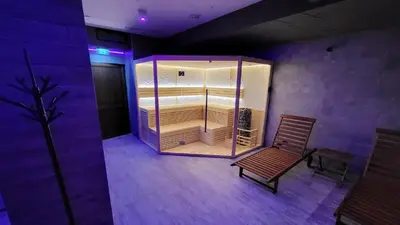 a empty room with a wooden chair and a room with purple lighting at The Bear Pamporovo in Pamporovo