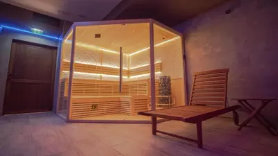 a room with a wooden chair and a glass case at The Bear Pamporovo in Pamporovo