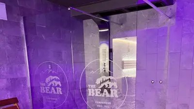 a purple room with a bear sign on a wall at The Bear Pamporovo in Pamporovo