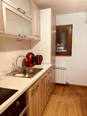 a kitchen with a sink and a red tea kettle at Spacious apartment with a Mountain view, big balcony and parking in Sofia