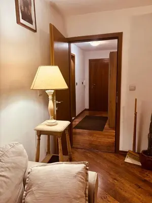 a room with a lamp on a table and a hallway at Spacious apartment with a Mountain view, big balcony and parking in Sofia