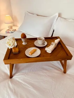 a wooden tray with breakfast foods on a bed at Spacious apartment with a Mountain view, big balcony and parking in Sofia