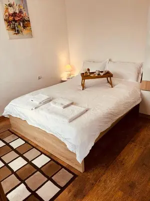 a large bed with a table on top of it at Spacious apartment with a Mountain view, big balcony and parking in Sofia