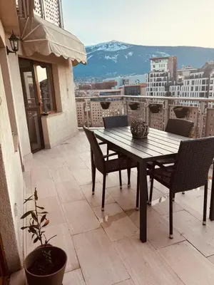 a table and chairs on a balcony with a view at Spacious apartment with a Mountain view, big balcony and parking in Sofia