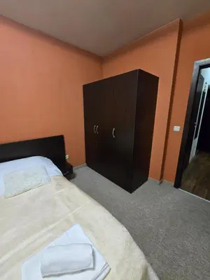 a bedroom with a bed and a dresser and a mirror at Lux apartment 223 in Bansko