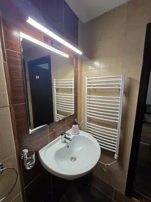 a bathroom with a white sink and a mirror at Lux apartment 223 in Bansko