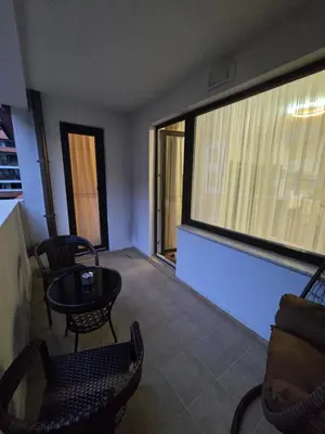 a room with chairs and a table and a large window at Lux apartment 223 in Bansko