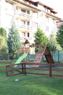 a wooden playground with a slide in a park at Lux apartment 223 in Bansko