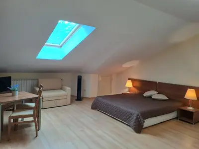 a bedroom with a bed and a couch and a skylight at Family Studio 407, Villa park in Borovets