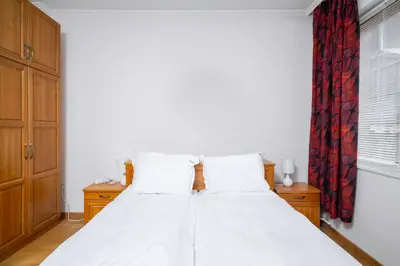 a bedroom with a white bed and a red curtain at 1BD flat with Desk on Russian Monument Square by Flat Mаnager in Sofia