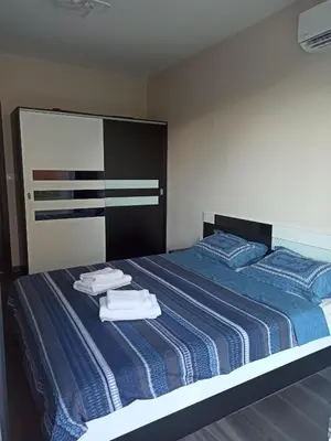 a bedroom with a blue striped bed with towels on it at Sunshine terrace in Plovdiv