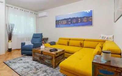 a living room with a yellow couch and a table at Spacious Sofia Condo - Philadelphia LOVE in Sofia