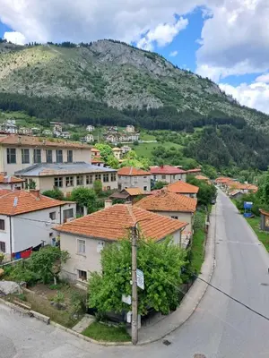 a village with houses and a mountain in the background at Katerci in Trigrad