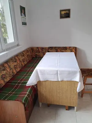 a table with a white table cloth on a couch at Katerci in Trigrad