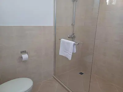 a bathroom with a shower with a white towel at Апартамент Престиж 1 in Hisarya