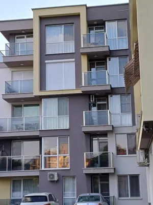 an apartment building with balconies and cars parked in front at Апартамент Престиж 1 in Hisarya