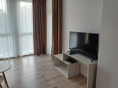 a living room with a flat screen tv on a stand at Апартамент Престиж 1 in Hisarya