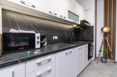 a kitchen with white cabinets and a microwave at 1-Bedroom apartment with Free Private parking in Plovdiv