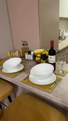 a table with two white plates and a bottle of wine at John Apartment 2 in Blagoevgrad