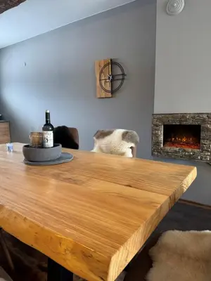 a wooden table in a room with a fireplace at Boris’s Guest Apartment in Chepelare