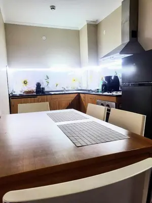 a kitchen with a wooden table and a refrigerator at Апартамент А101 хотел Снежанка in Pamporovo