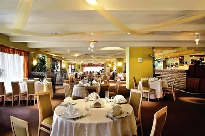 a dining room with white tables and chairs at Апартамент А101 хотел Снежанка in Pamporovo