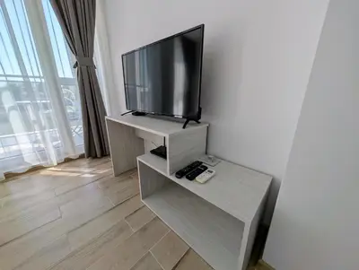 a living room with a flat screen tv on a stand at Апартамент - Студио Престиж 2 in Hisarya