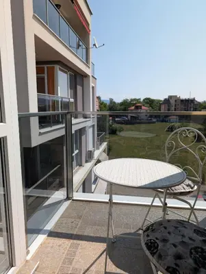 a patio with a table and chairs on a balcony at Апартамент - Студио Престиж 2 in Hisarya