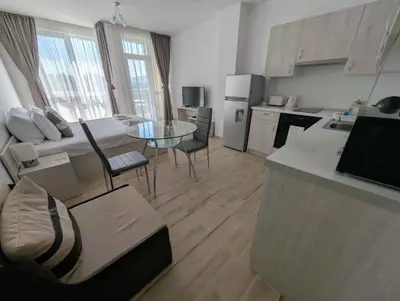 a kitchen and living room with a table and chairs at Апартамент - Студио Престиж 2 in Hisarya