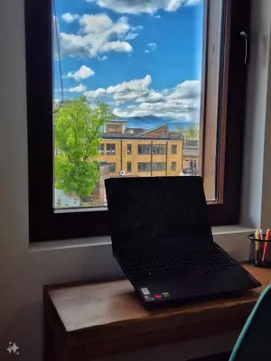 a laptop sitting on a table in front of a window at Wooden Paradise Apartment next to Gondola in Bansko