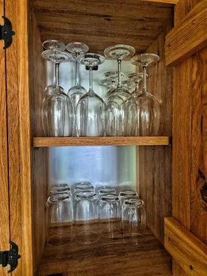 a bunch of wine glasses sitting on a shelf at Wooden Paradise Apartment next to Gondola in Bansko