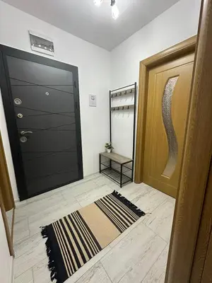 a hallway with a black door and a rug at Shtastliveca Guest Apartment in Velingrad