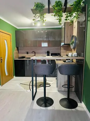a kitchen with two bar stools at a counter at Shtastliveca Guest Apartment in Velingrad