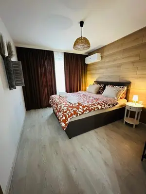 a bedroom with a large bed and a table at Shtastliveca Guest Apartment in Velingrad