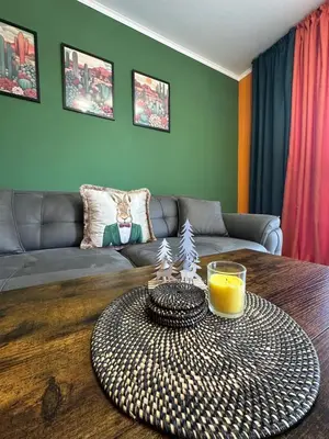 a living room with a table with a glass of orange juice at Shtastliveca Guest Apartment in Velingrad