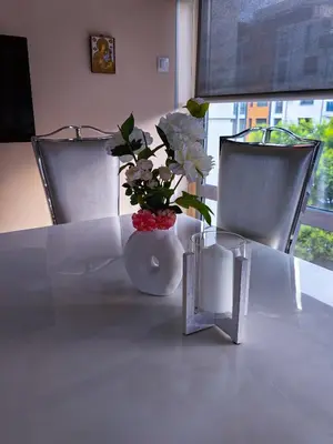 a white vase with flowers in it on a table at The View Apartment in Plovdiv