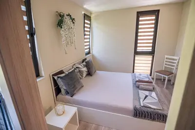 a small bedroom with a bed and a chair at ДиНати in Plovdiv