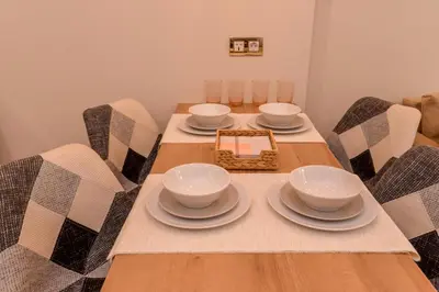 a dining room table with bowls and plates on it at Elegant 1BD Stay on Ekzarh Yosif, Sofia by Flat Mаnager in Sofia