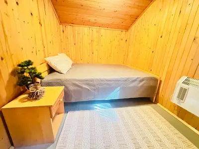 a bedroom with a bed in a wooden room at Вила Данели in Tsigov Chark